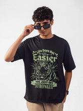 male model wearing black you just get stronger oversized graphic t shirt showing the front side