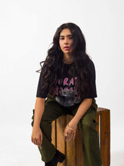 Female model wearing black oversized graphic t shirt showing front in sitting position Attire Essentials