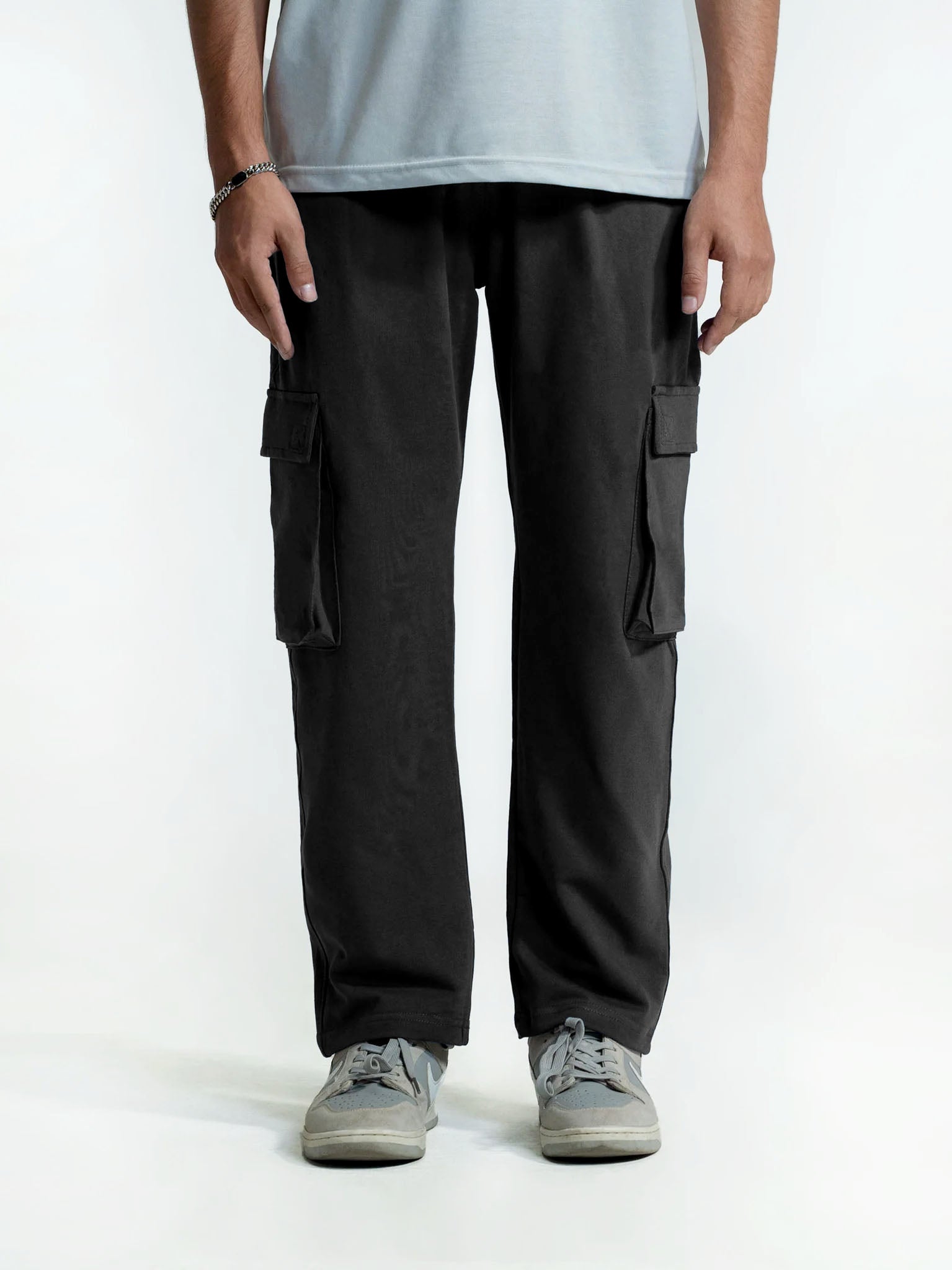 Person wearing black cargo trouser on a white background
