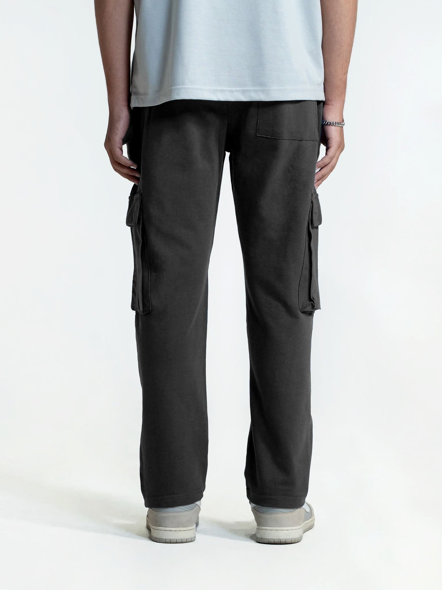 Person wearing black cargo trouser on a white background