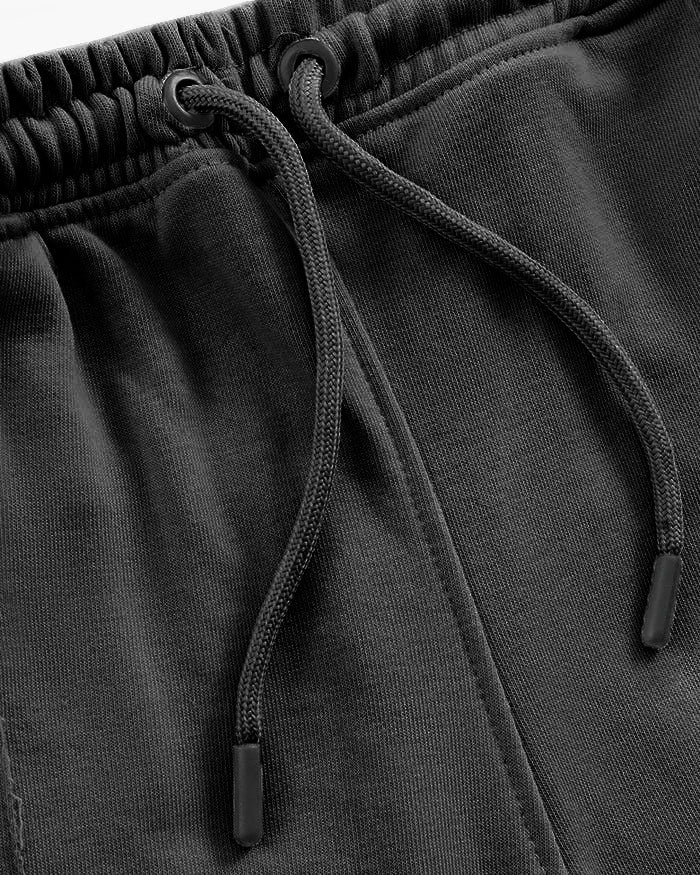 Close-up of black drawstring trouser with a focus on the drawstring and waistband.