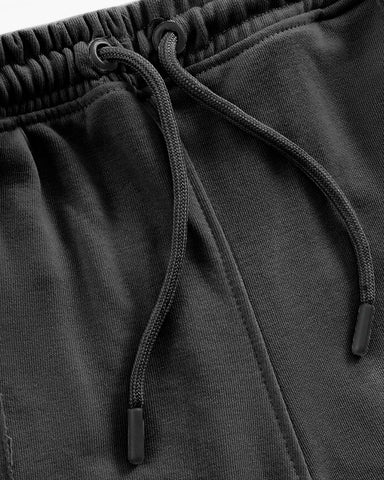 Close-up of black drawstring trouser with a focus on the drawstring and waistband.