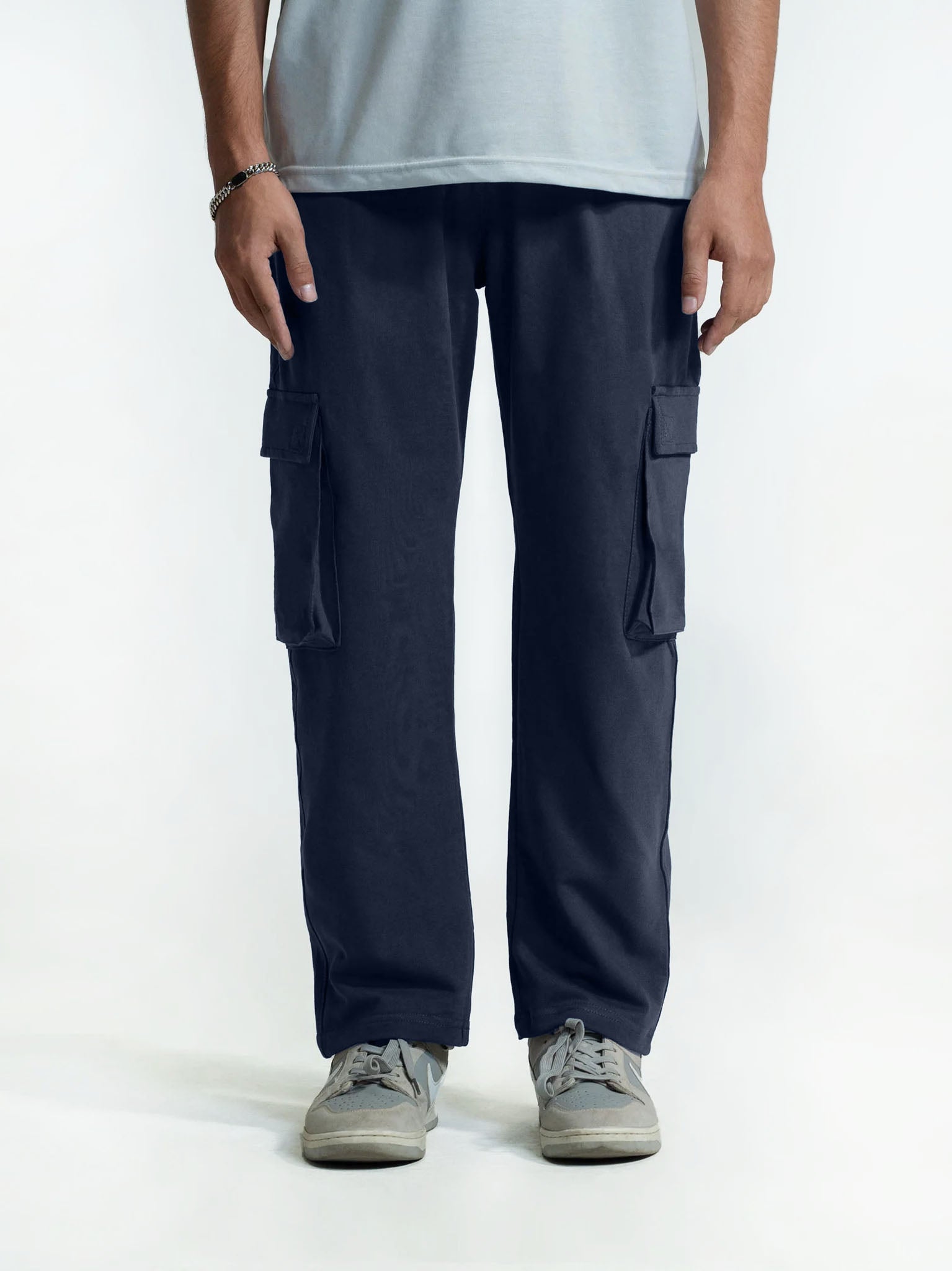 Person wearing navy cargo trouser on a white background