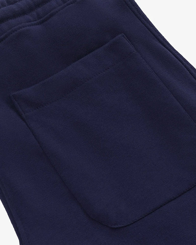 Close-up of navy blue straight pleated trouser with a pocket on a white background