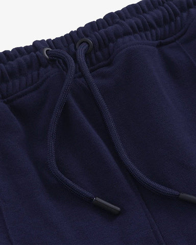 Close-up of navy blue straight pleated trouser with drawstring