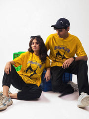 both male and female model wearing yellow wolverine oversized graphic t shirt showing front side while sitting