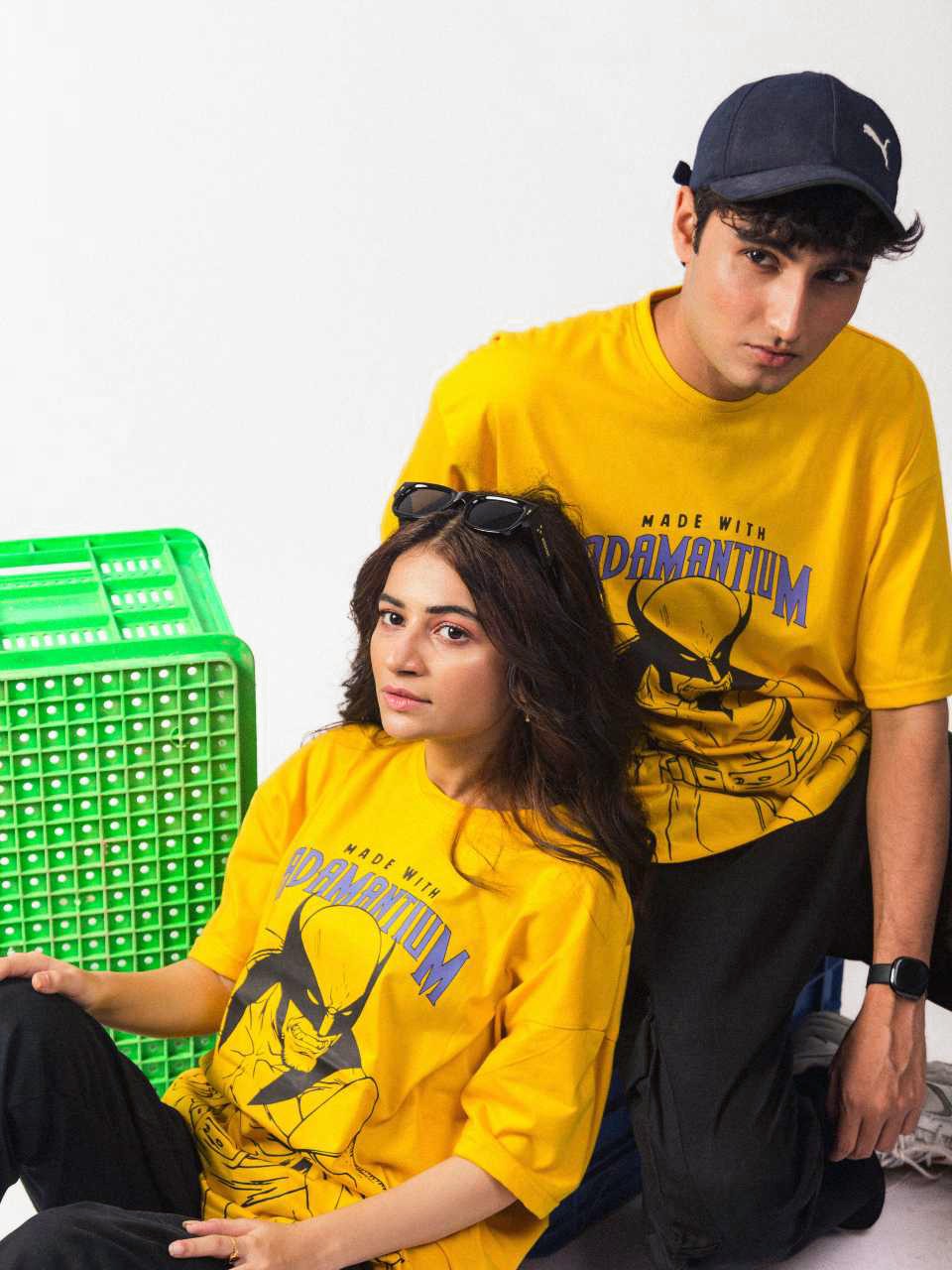 both male and female model wearing yellow wolverine oversized graphic t shirt showing side view while sitting
