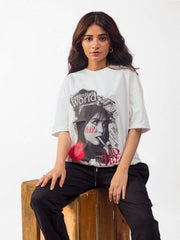 female model wearing white essentials oversized graphic t shirt showing the front side in a sitting position