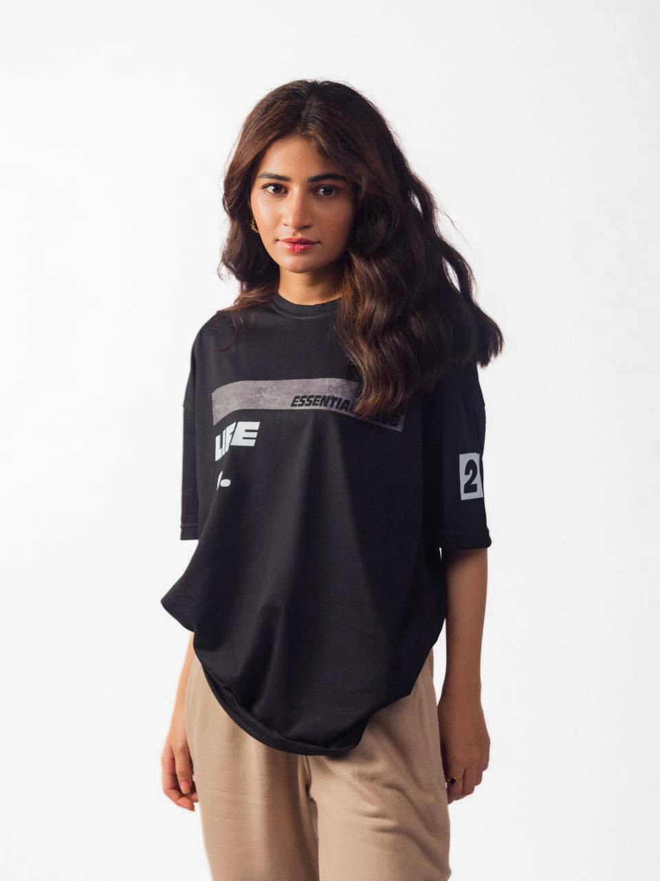 female model wearing black essentials club oversized graphic t shirt showing the front of the t shirt
