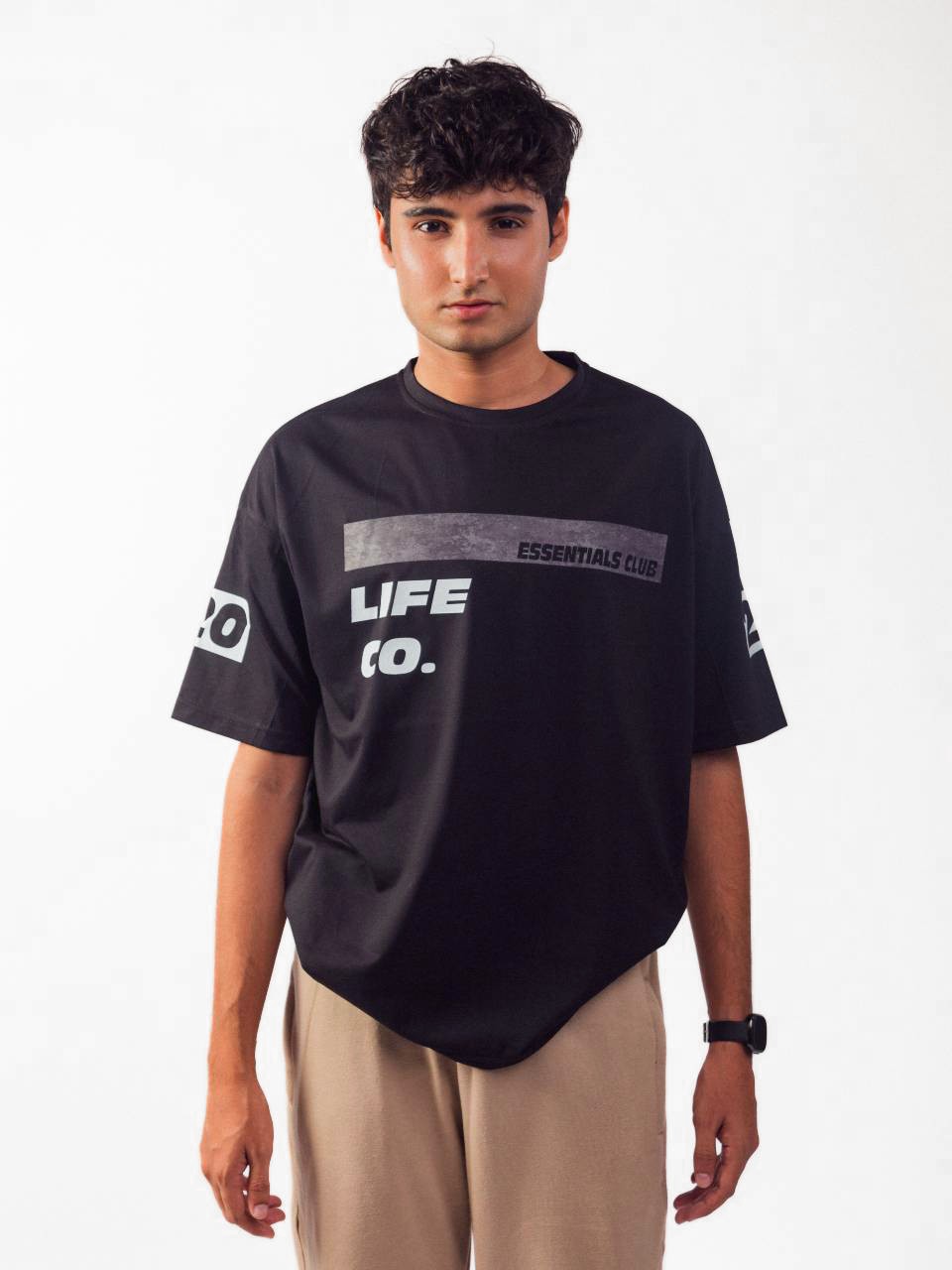 male model wearing black essentials club oversized graphic t shirt showing the front of the t shirt