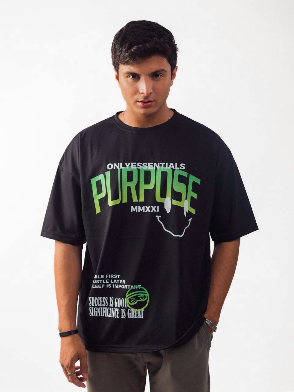 male model wearing black essentials purpose oversized graphic t shirt showing the front of the t shirt
