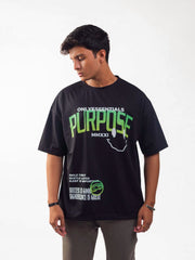 male model wearing black essentials purpose oversized graphic t shirt showing the front of the t shirt while standing