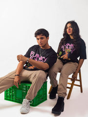 Male and female model wearing black funky funky oversized graphic t shirt showing side view while sitting Attire Essentials