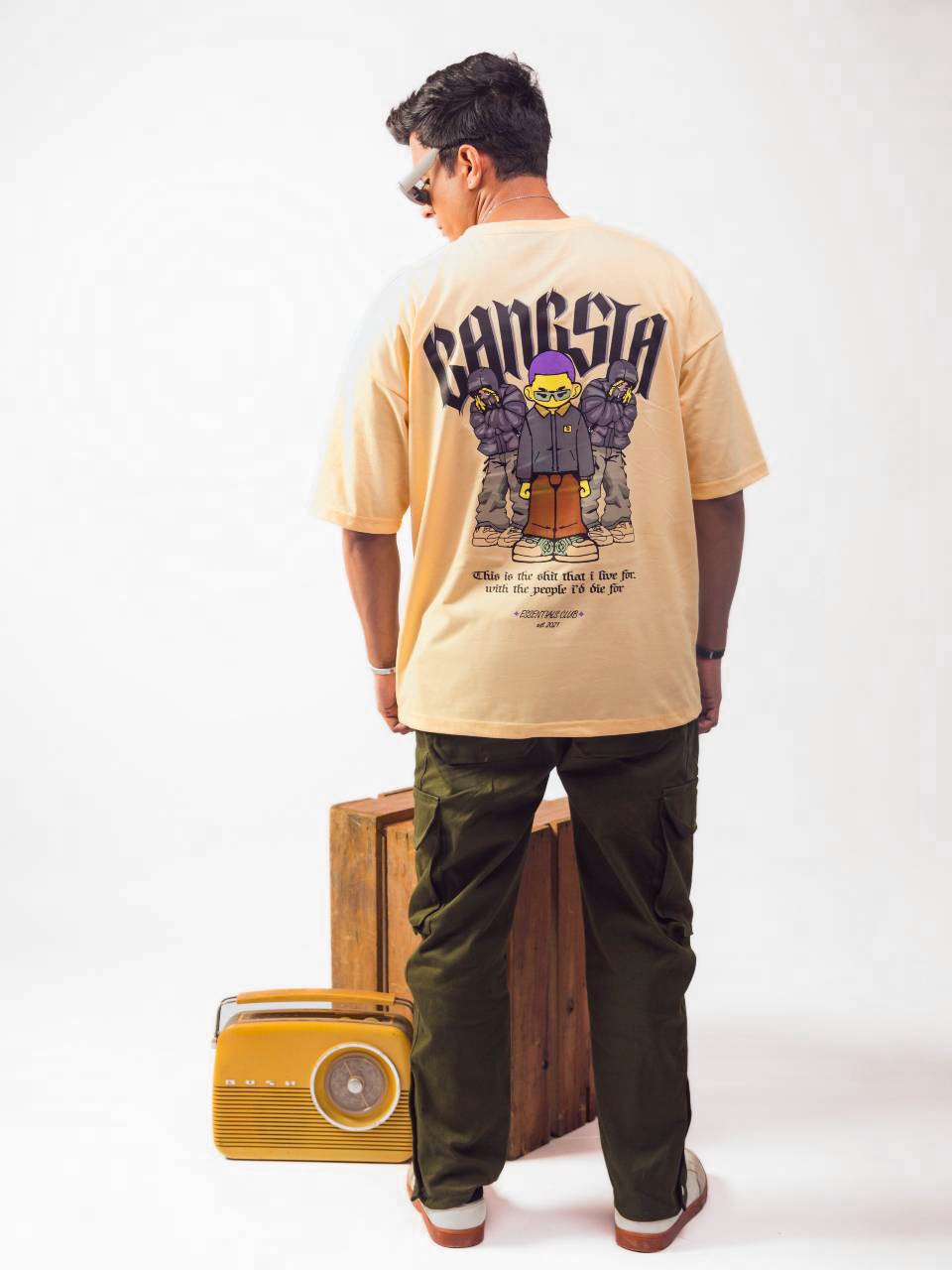 Male model wearing beige gangsta oversized graphic t shirt showing the back view Attire Essentials