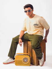Male model wearing beige gangsta oversized graphic t shirt showing the side view Attire Essentials