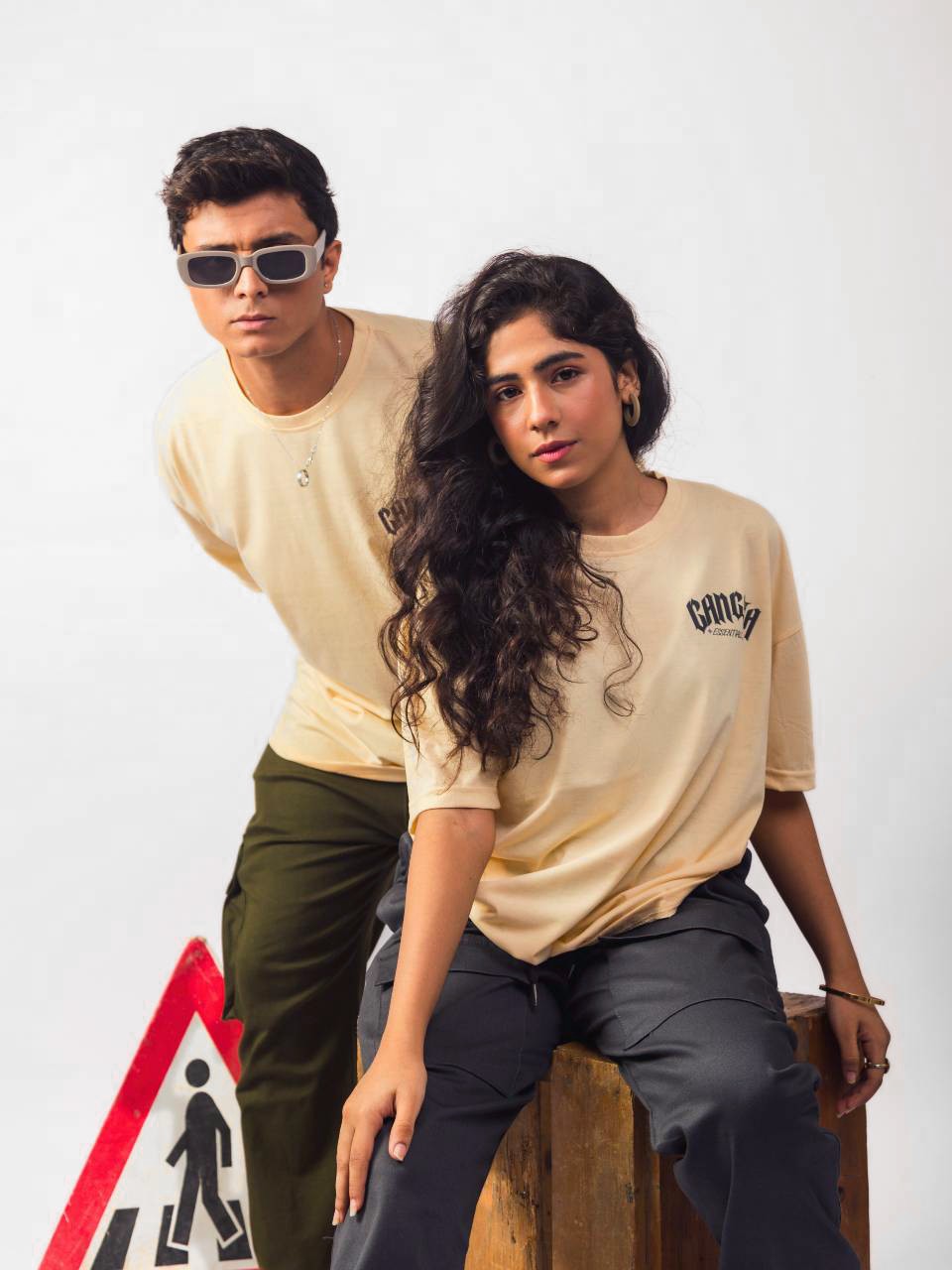 Male and female model wearing beige gangsta oversized graphic t shirt showing the front view Attire Essentials