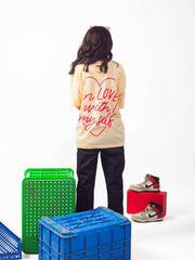 female model wearing beige in love with myself oversized graphic t shirt showing the back of the t shirt 