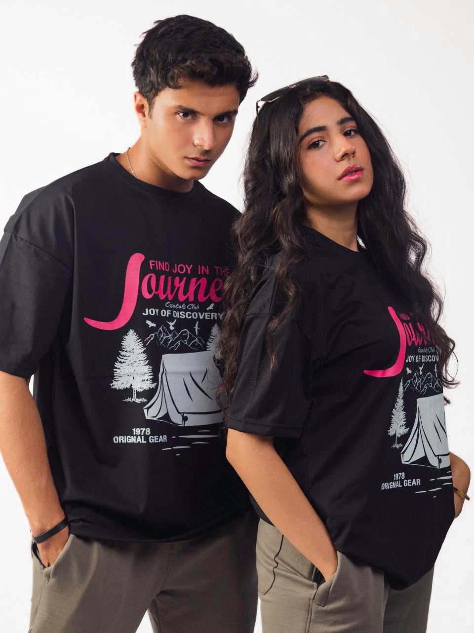 female and male model wearing black joy in the journey oversized graphic t shirt showing the front and side view of the t shirt