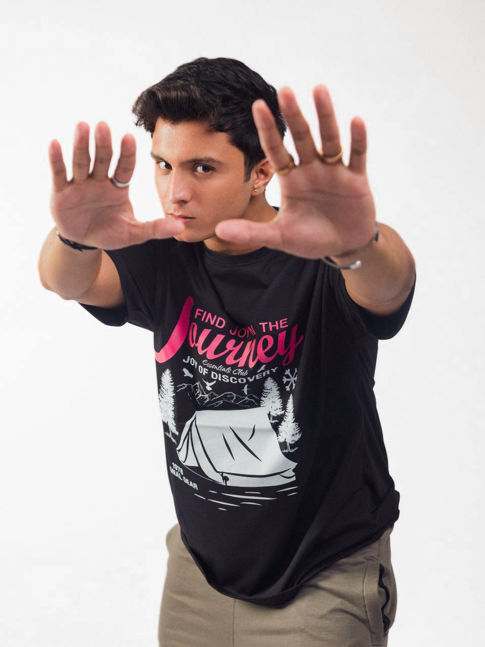 male model wearing black joy in the journey oversized graphic t shirt showing the front side of the t shirt while posing