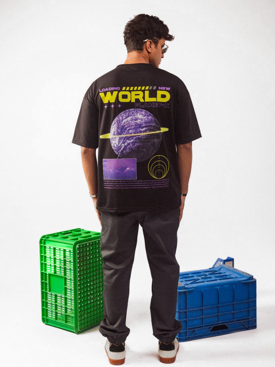 Male model wearing black loading new world oversized graphic t shirt in which male model showing the back side of the t shirt