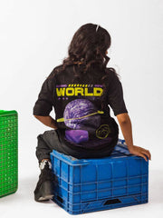 female model wearing black loading new world oversized graphic t shirt in which female model showing the back side of the t shirt in sitting position