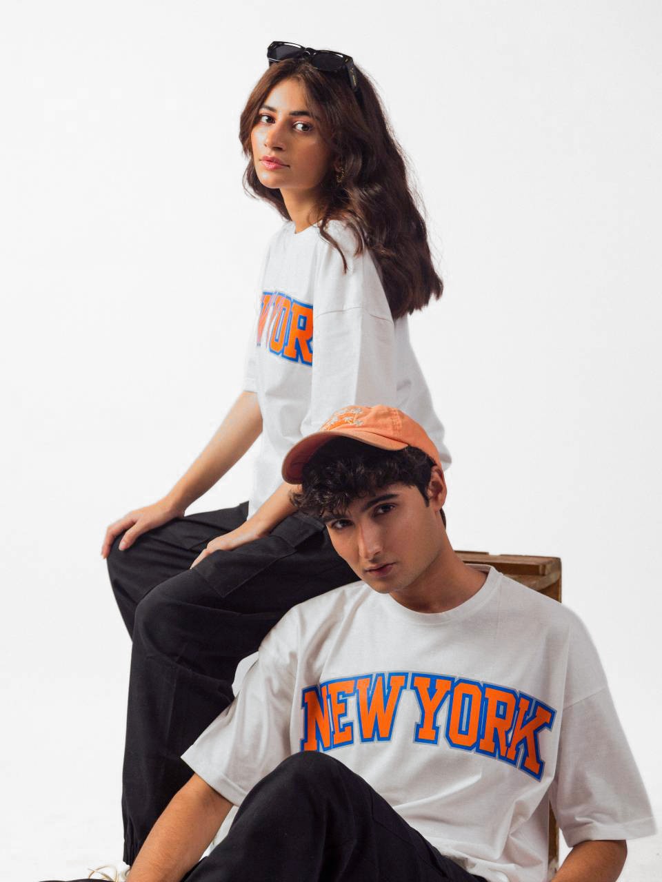 male and female model wearing white newyork oversized graphic t shirt showing front and right side of the t shirt