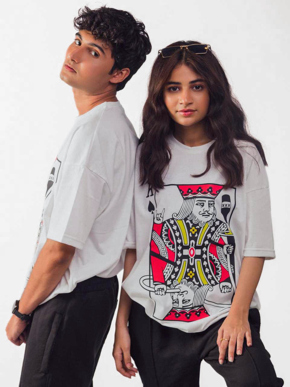 Male and female model wearing Party King oversized white graphic t-shirt showing front and side view Attire Essentials