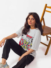 Female model wearing Party King oversized white graphic t-shirt showing left side while sitting Attire Essentials