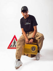 male model wearing black refuse to be ordinary oversized graphic t shirt showing front view of the t shirt