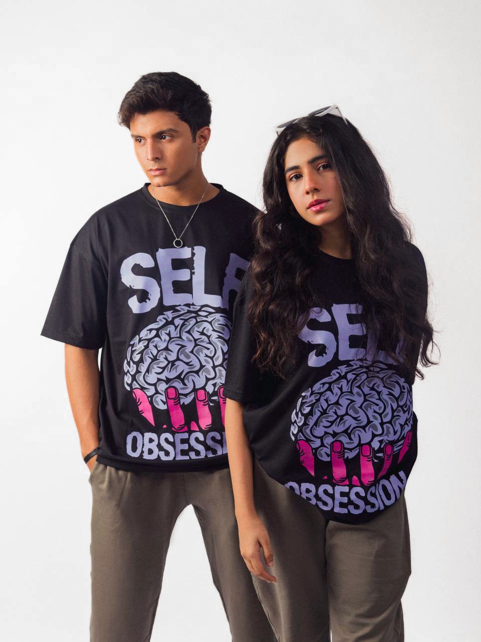 Female and male model wearing black self obsession oversized graphic t shirt showing front side 