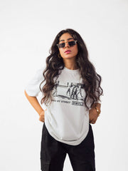 female model wearing white street dwellers oversized graphic t shirt showing the front side