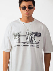 male model wearing white street dwellers oversized graphic t shirt showing the front side in a detailed view