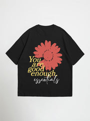 Black you are good enough essentials oversized graphic t-shirt with a red flower and motivational text on a white background
