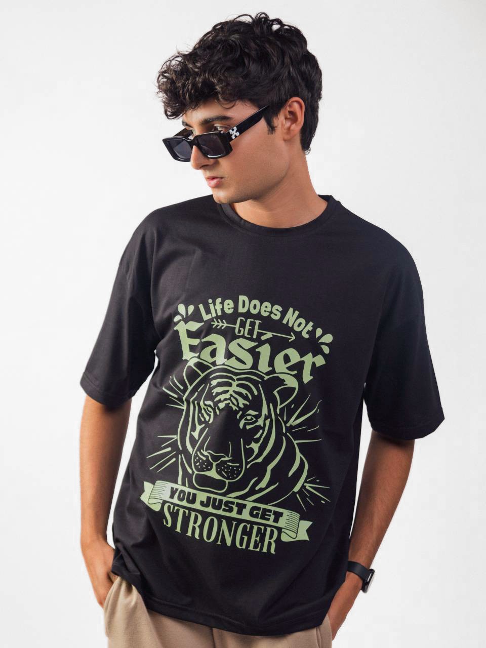 male model wearing black you just get stronger oversized graphic t shirt showing the front side while standing