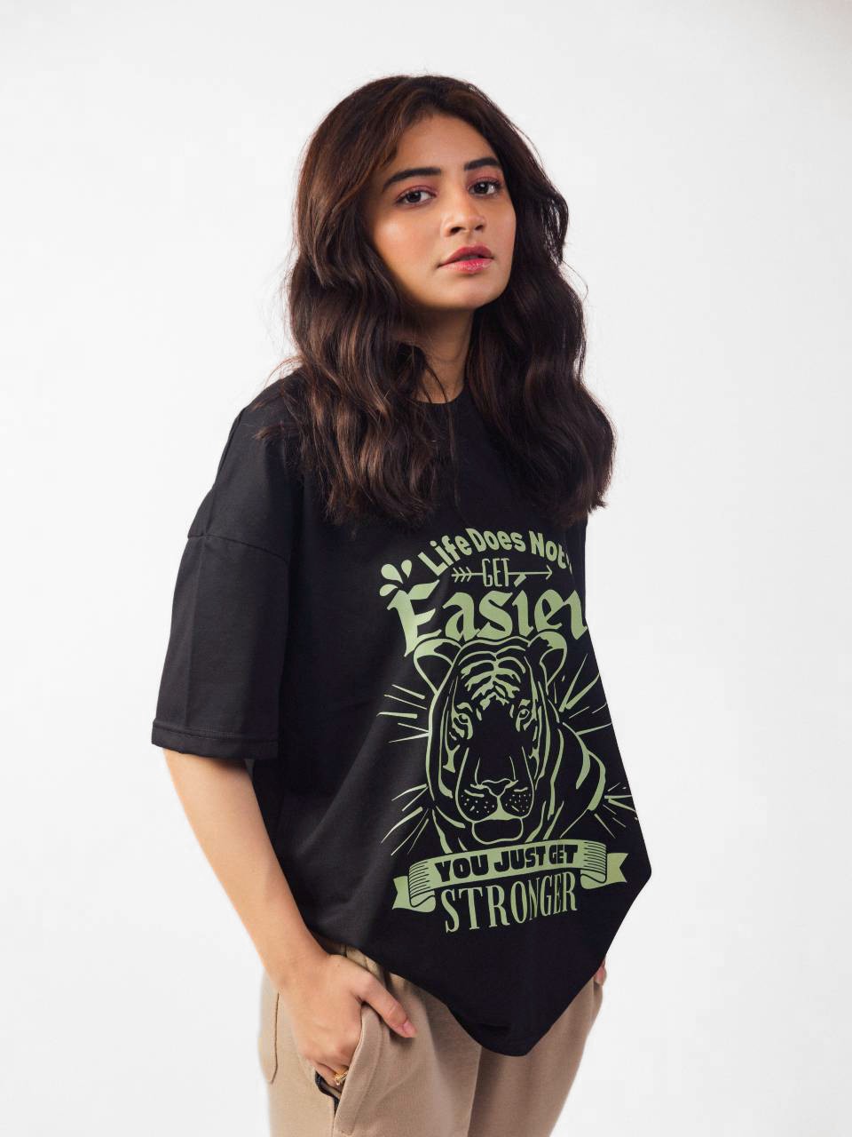 female model wearing black you just get stronger oversized graphic t shirt showing the side view