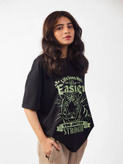 female model wearing black you just get stronger oversized graphic t shirt showing the side view