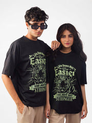 male and female model wearing black you just get stronger oversized graphic t shirt showing the front side